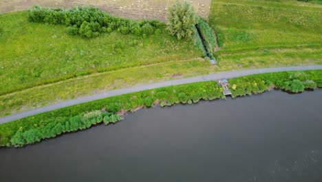 Dendre-river-and-sheep-herd-grazing-nearby,-aerial-view