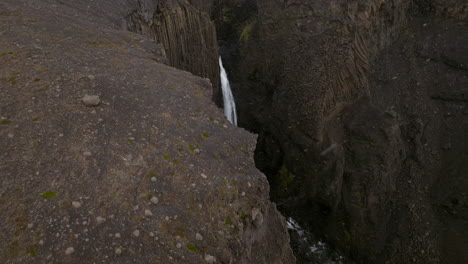 Litlanesfoss-Waterfall-With-Basalt-Columns-During-Snowfall-In-Iceland---Drone-Shot