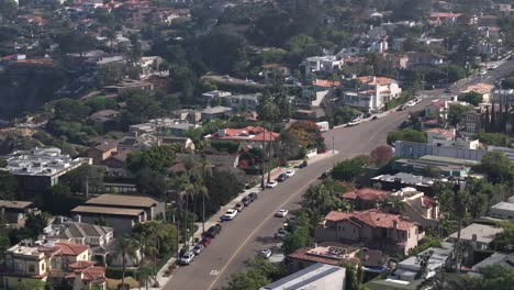 La-Jolla-neighborhood-with-lush-greenery-and-coastal-homes,-sunny-day,-aerial-view