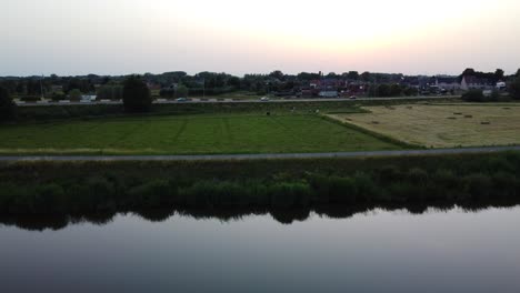 Ascend-over-Dendre-River-and-reveal-of-Aalst-township,-aerial-view