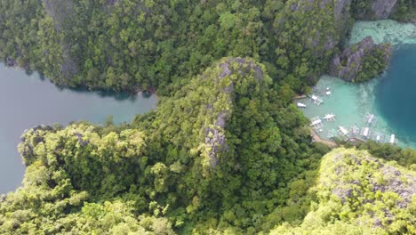 Lush-karst-landscape-and-tour-boats-at-Kayangan-lake-in-Coron,-Aerial