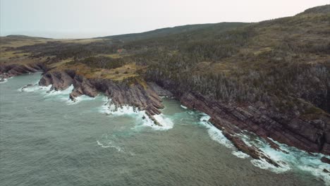 Small-rocky-beach-hidden-along-dramatic-and-rugged-coastal-cliffs