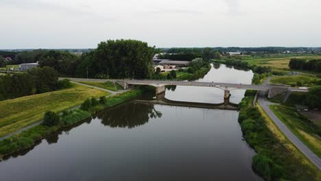 Green-landscape-and-concrete-bridge-over-Dendre-river,-aerial-view