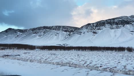 Snowy-mountain-range-viewed-from-car-on-Icelande-road-trip-in-Grundarhverfi