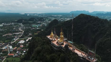 Aerial-establishing-of-Tiger-Cave-Temple-or-Wat-Tham-Suea-with-view-of-village-below