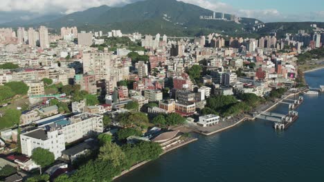 Bezirk-Tamsui,-Taipei,-Mit-Stadtlandschaft,-Grünen-Hügeln-Und-Uferpromenade,-An-Einem-Sonnigen-Tag,-Luftaufnahme