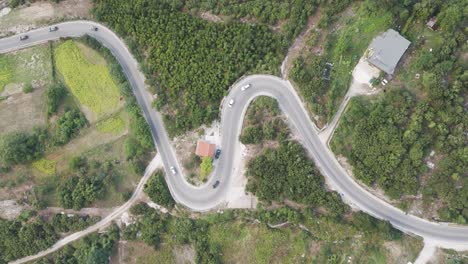 Aerial-view-of-cars-drive-in-close-line-on-Albanian-mountain-serpentine-road