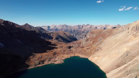Slow-panning-drone-shot-at-12,000-feet-elevation-showing-a-lake-and-mountain-peaks