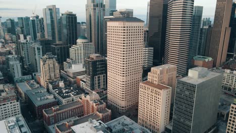 Aerial-orbital-parallax-around-beige-and-modern-sleek-silver-downtown-skyline-buildings-of-Seattle-Washington