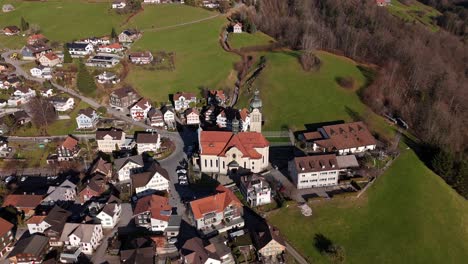 Aerial-of-landmark-church-in-quaint-Swiss-village---Rieden,-Switzerland