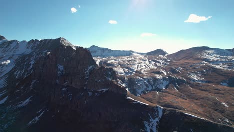 Drone-flying-around-a-peak-of-a-snow-covered-mountain-in-the-San-Juan-mountains