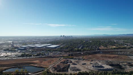 Aerial-drone-flyover-of-a-busy-highway-in-Denver,-CO-and-industrial-buildings