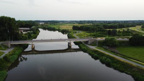 Bridge-leading-over-Dendre-river-in-Belgium,-aerial-view