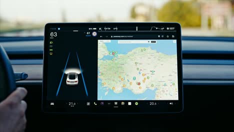 Close-up-of-Tesla-car-sensor-touchscreen-monitor-with-different-apps,-functions-and-capabilities,-autonomous-navigating-system-controlling-road-traffic,-speed-and-battery