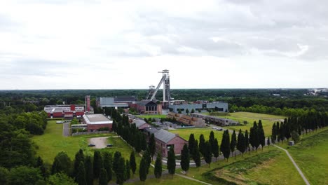 Industrial-complex-with-tower-and-green-surroundings,-aerial-drone-view
