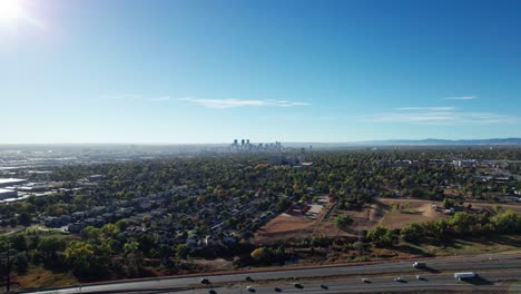 Drone-shot-rising-up-over-a-highway-outside-of-Denver,-CO-on-a-sunny-fall-day