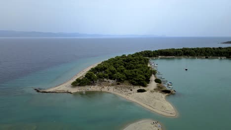 Cinematic-rotating-4K-drone-clip-over-a-peninsula-in-Paliouri,-Chalkidiki-in-North-Greece