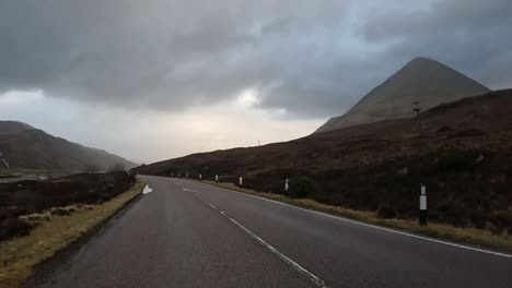 Empty-road-winding-through-the-moody-landscapes-of-Skye-Island,-Scotland-under-overcast-skies