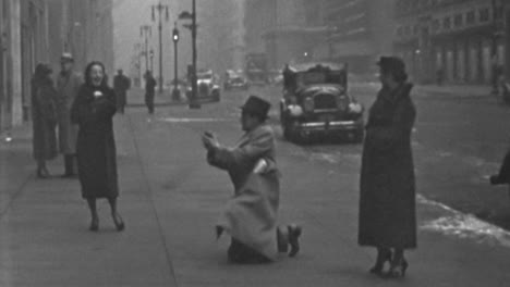 Mann-In-Langem-Mantel-Und-Hut-Kniet-In-Den-1930er-Jahren-Bettelnd-Auf-Einem-New-Yorker-Bürgersteig