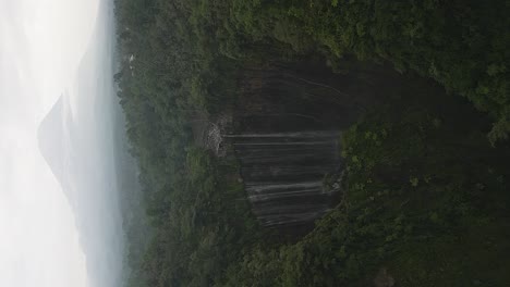 Vertical-format:-Stunning-Tumpak-Sewu-waterfall-with-Java-volcano-cone