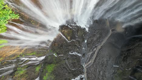 Aerial-looks-down-onto-dramatic-Tumpak-Sewu-waterfall-grotto-on-Java
