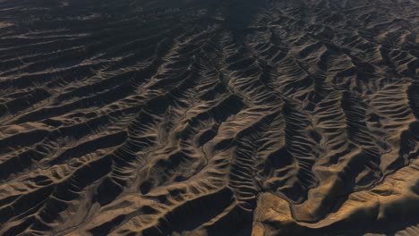 Filmische-Luftaufnahme-Einer-Seltsamen-Kargen-Landschaft-Aus-Bergrücken-Und-Tälern,-Factory-Butte,-Utah
