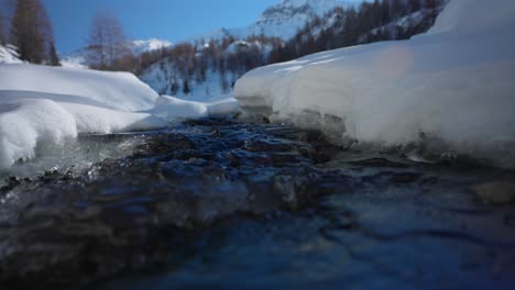Nahaufnahme-Von-Süßwasserabfluss-Aus-Schmelzendem-Schnee-An-Sonnigen-Tagen,-Frühling-In-Den-Bergen