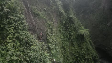 Ein-Männlicher-Tourist-Klettert-Eine-Steile-Treppe-Hinauf-In-Die-Neblige,-Schmale-Java-Dschungelschlucht