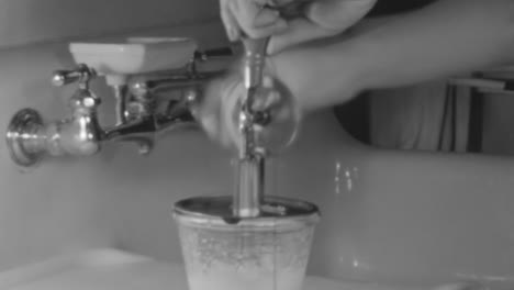 Eine-Frau-Macht-Kuchenglasur-Mit-Einem-Antiken-Handmixer-Im-New-York-Der-1930er-Jahre