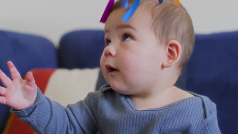 Baby-Spielt-Mit-Regenbogen-Seidenbändern-In-Zeitlupe