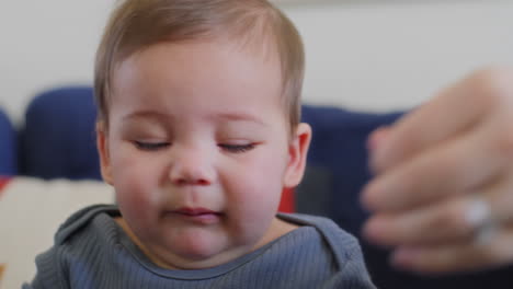 baby-boy-with-boogers-on-his-nose-gets-them-wiped-away-by-moms-hands