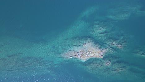 Overhead-4K-drone-clip-over-a-rock-formation-in-the-tropical-blue-waters-of-Toroni-in-Chalkidiki