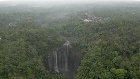 Aerial-view-of-misty-jungle-waterfall,-Tumpak-Sewu-in-Java-Indonesia