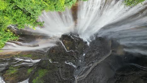 Aerial-spins-straight-down-Tumpak-Sewu-waterfall-cliff-on-Java,-IDN