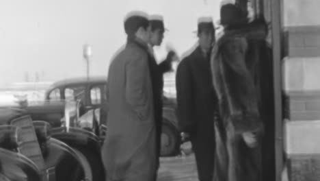 Hombres-Con-Elegantes-Trajes-Y-Sombreros-Entran-A-Un-Edificio-En-Nueva-York-En-Los-Años-30