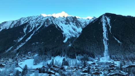 Ski-resort-of-Chamonix,-France-with-the-Alps-mountains-towering-above-the-town-on-a-cold-snowy-winter-day