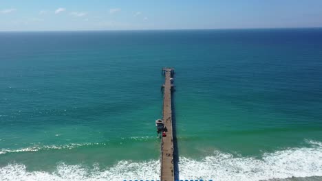 4k-Forward-moving-aerial-shot-looking-out-towards-Pacific-Ocean,-over-San-Clemente-Pier,-in-Orange-County,-California