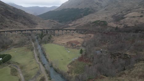 The-historic-glenfinnan-viaduct-in-scotland-surrounded-by-rugged-landscapes,-aerial-view