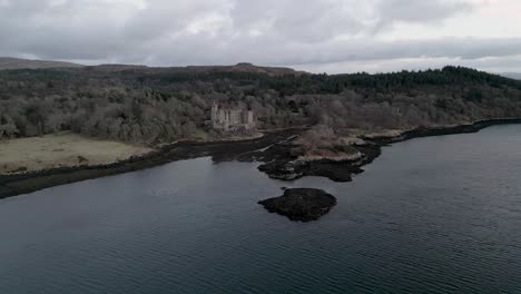 Dunvegan-castle-on-the-isle-of-skye,-surrounded-by-woodland-and-coastline,-aerial-view