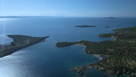 Cinematic-rotating-up-high-4K-drone-clip-over-the-tropical-blue-waters-of-Toroni-in-Chalkidiki