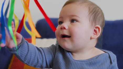 baby-playing-with-rainbow-silk-ribbons-in-slow-motion