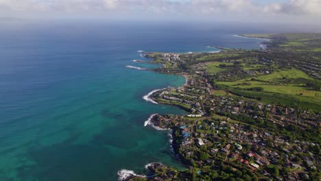High-angle-sweeping-aerial-view-of-Kahana-Maui-coastline-and-communities-overlooking-ocean-reef