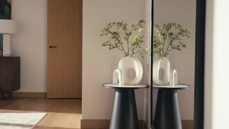 panning-shot-of-a-small-side-table-with-a-plant-a-modern-vase-and-a-modern-piece-of-art