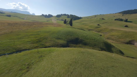 FPV-drone-aerial-view-speeding-across-Italian-Dolomites-lush-countryside-chalets-passing-farmland-animals