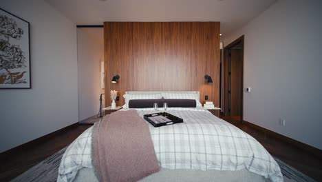 Ein-Luxuriöses-Schlafzimmer-Mit-Weißer-Bettwäsche-Und-Einem-Kopfteil-Aus-Holz-An-Der-Wand,-Breites,-Einschiebbares-Bett-Direkt-Am-Bett