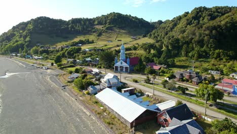 Aerial-view-of-the-dolly-in-Tenaun-and-its-patrimonial-church-in-the-Chiloé-Archipelago,-southern-Chile