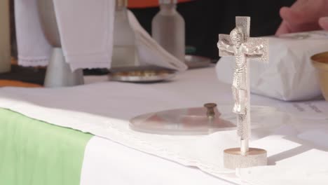 A-small-silver-crucifix-stands-on-an-outdoor-altar