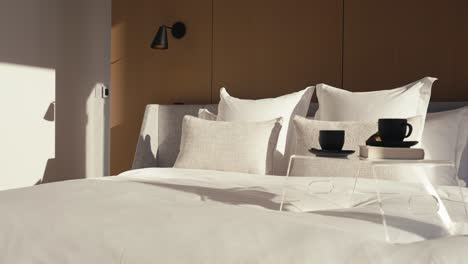 a-luxury-bedroom-with-a-large-white-king-bed-and-a-bed-side-table-on-it-which-includes-2-black-coffee-mugs-and-a-book