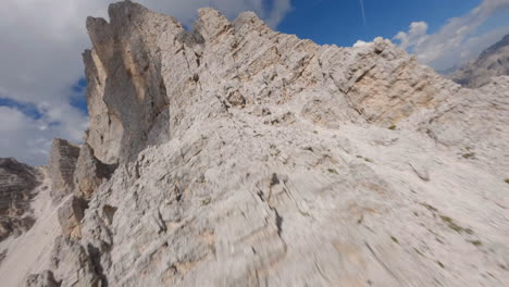 FPV-drone-ascending-sharp-rocky-Dolomites-Italian-mountain-range-ridge-peaks