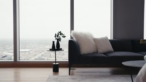 Schwenk-Einer-Schwarzen-Couch-Mit-Weißen-Kissen-Und-Einem-Kleinen-Beistelltisch-Vor-Großen-Fenstern-In-Einer-Hochhauswohnung